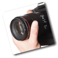 Fotocursus Basis hand houdt camera bij de lens vast